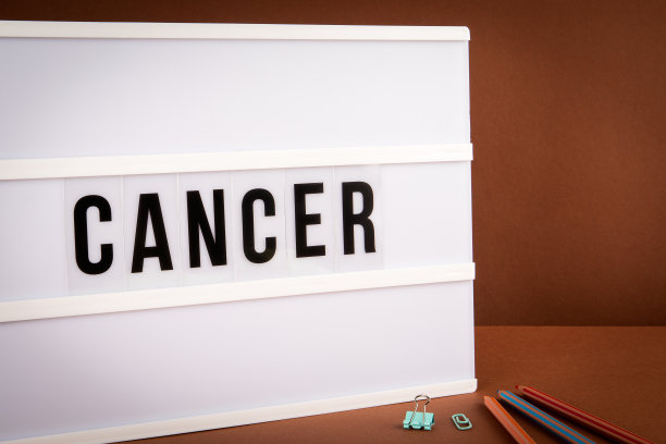 癌症。在棕色背景上有文字的灯箱。疾病与人类健康图片下载