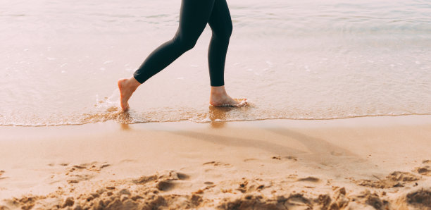 日落时分，女人在沙滩上奔跑的特写照片图片下载