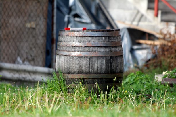 复古的老式大木酒桶，生锈的金属箍和破旧的木板离开了家的后院图片下载