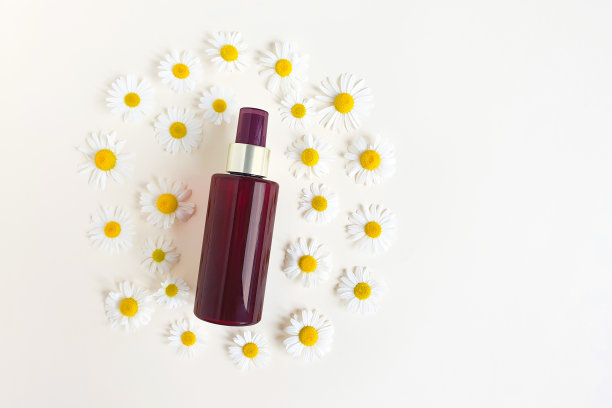 棕色喷雾瓶的模型品牌和甘菊。俯视图，扁平的生活方式。天然有机spa化妆品概念。图片下载