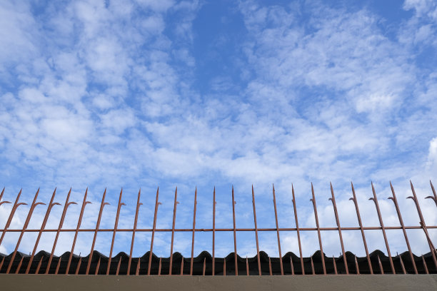 坚固的金属边墙，保护私人自由。安全围栏上面有铁箭图片下载