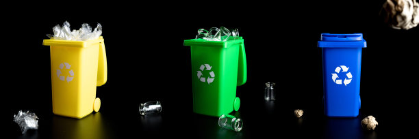 垃圾桶设置。黄色、绿色、蓝色垃圾桶，用于回收塑料、纸和玻璃等垃圾，隔离在黑色背景上。容器处理垃圾废物，节约环境。图片下载