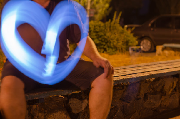 离焦拍摄的成年男子与蓝色的灯光在城市图片下载