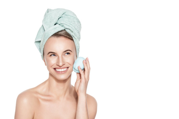 年轻女子用硅胶洁面刷。护肤和美容概念肖像在白色的背景。去角质，面部按摩，卸妆。图片下载