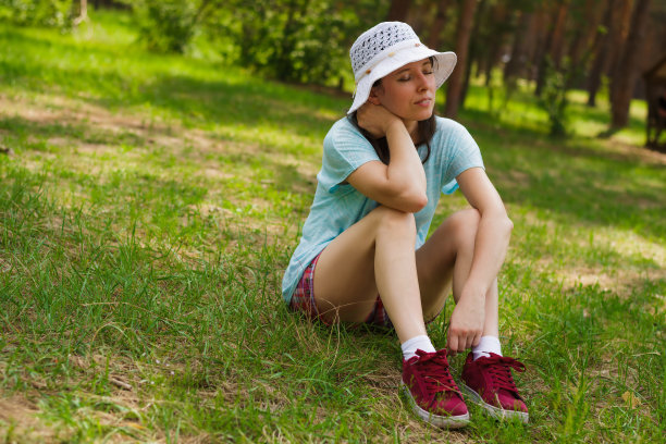 一位中年妇女正坐在草地上，放松休息图片下载