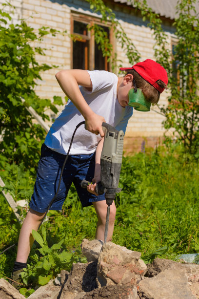 在户外工作的打孔的男孩图片下载