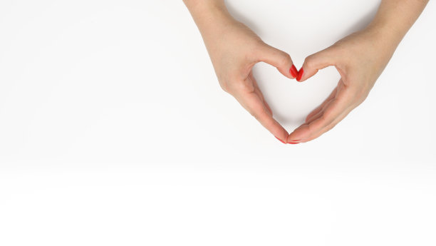 在白色背景上，两只女性的手合拢成心形。感恩与善良观念图片下载