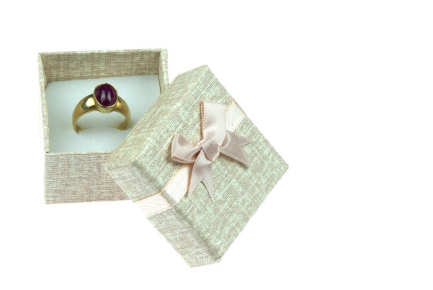 打开礼盒，白色背景上有一个大的金戒指。图片下载