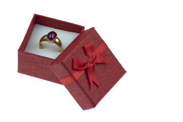 打开礼盒，白色背景上有一个大的金戒指。图片下载