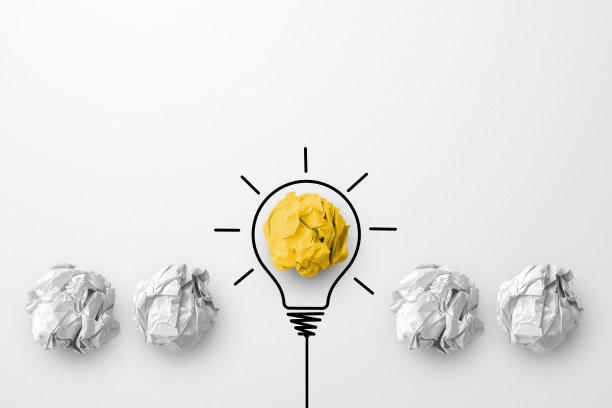 概念、创意、思想、创新。纸屑球黄色的颜色突出不同组别与灯泡的符号图片下载