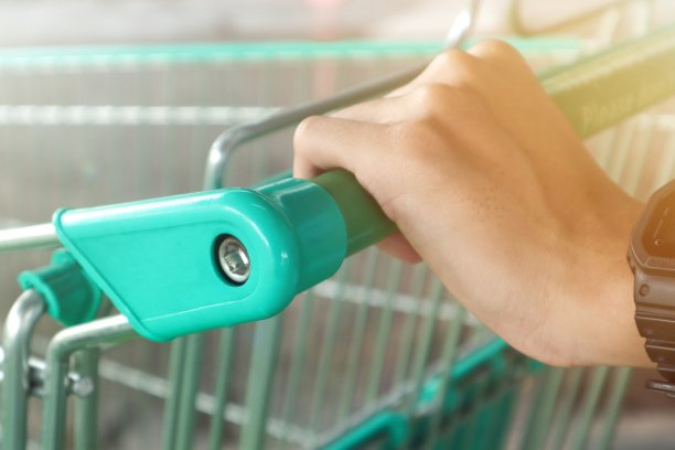 一名男子在超市推购物车。图片下载