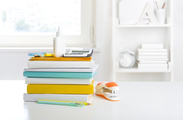 白色书架背景上堆放着学校的课本和用品图片下载