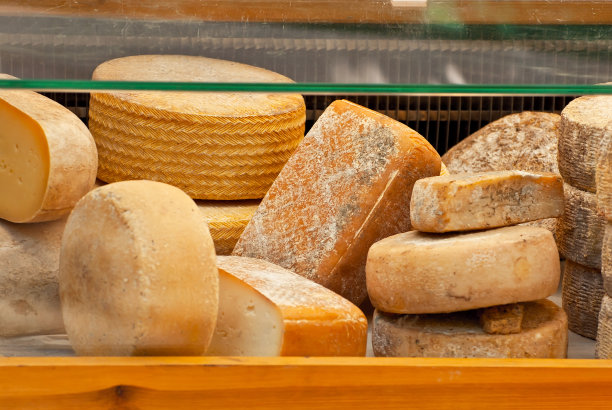 桌上有不同种类的奶酪。农贸市场上有许多奶酪出售。自然产品。图片下载