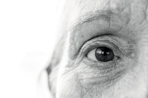黑白特写老妇人的眼睛，正面的观点，背景与复制空间图片下载