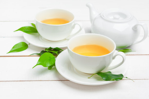 茶壶和茶杯在白色木制背景上图片下载