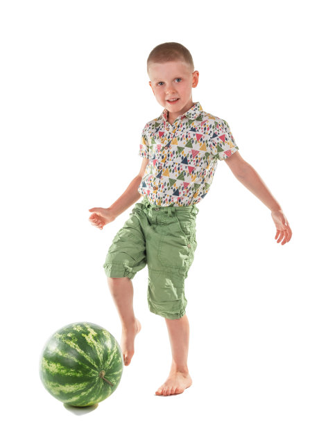 的概念。开心男孩玩西瓜足球孤立在白色上图片下载