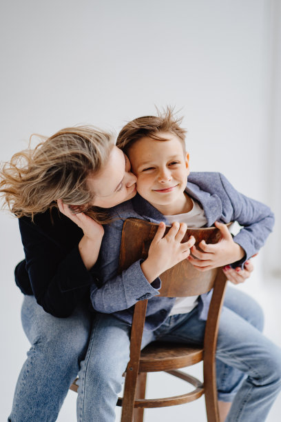 一位母亲带着穿着蓝色衣服的儿子玩耍，摆姿势拍照图片下载