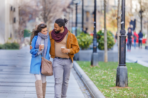 年轻的非裔美国人在公园里拥抱他可爱的妻子。图片下载