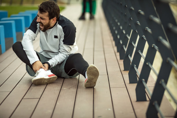 一名年轻人在晨练时脚踝受伤图片下载
