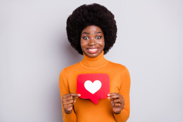 照片肖像兴奋的黑色皮肤女孩拿着像标志与双手孤立在清楚的灰色背景图片下载