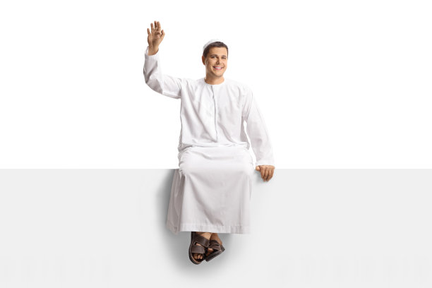 一名身着民族服装的男子的全身肖像，坐在一块白色的面板上，向镜头挥手图片下载