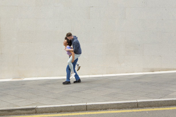 多种族的夫妇非洲女人背着年轻的白人男子在她的背后笑图片下载