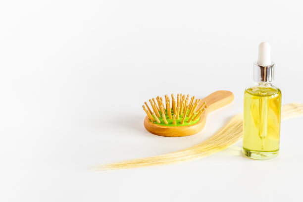 头发精油与木刷和金色卷发图片下载