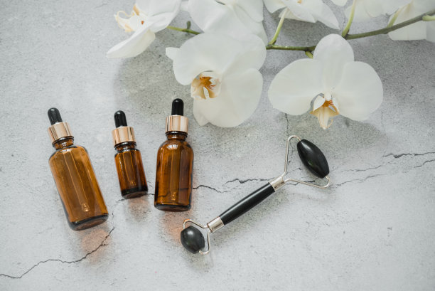 精华液或精油瓶与瓜沙按摩辊水疗和自然护肤，身体和皮肤护理自然治疗，水疗化妆品品牌模型图片下载