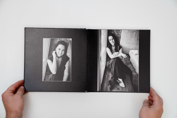 手握一本打开的照片簿从照片拍摄的一个女人在白色的背景。图片下载