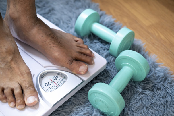 亚洲足男用体重秤测量体重减轻。秤到健康减肥概念图片下载