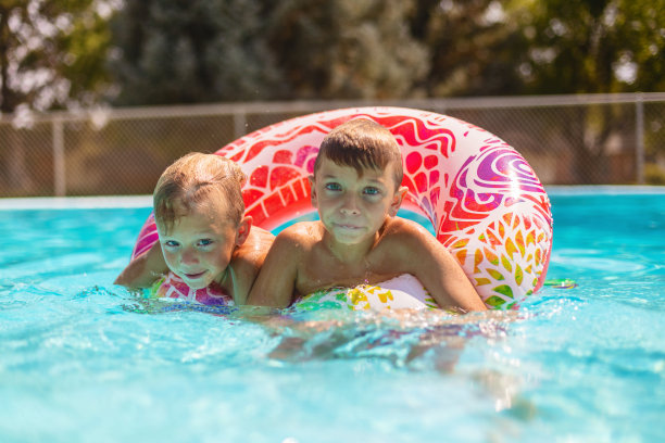 两个小男孩在游泳池一起玩在夏天的时间有趣的照片系列图片下载