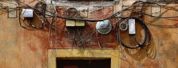 在一所废弃的老房子的正面，缠结着一团又老又乱的电缆图片下载