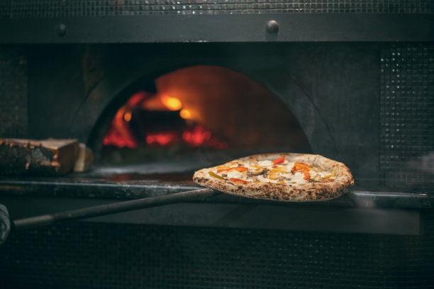 烘培美味，美味的披萨。餐厅里的大火炉和燃烧的木头。图片下载