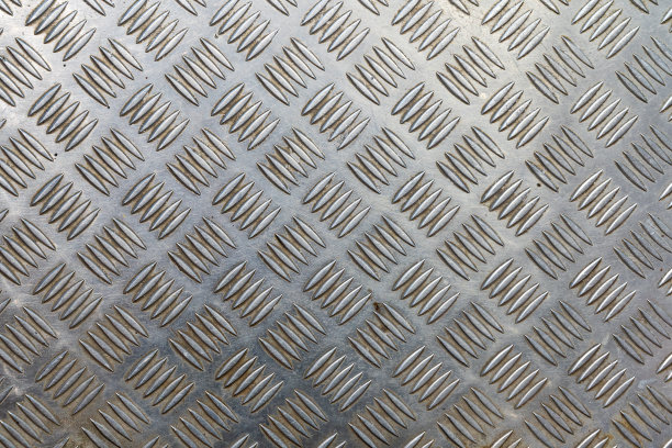 旧不锈钢板与银波纹。突出物之间有污垢。背景。纹理。图片下载