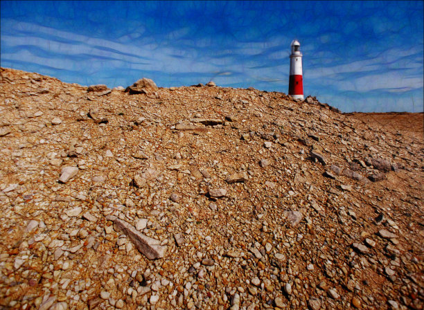 在岩石海岸线上的红白相间的灯塔图片下载