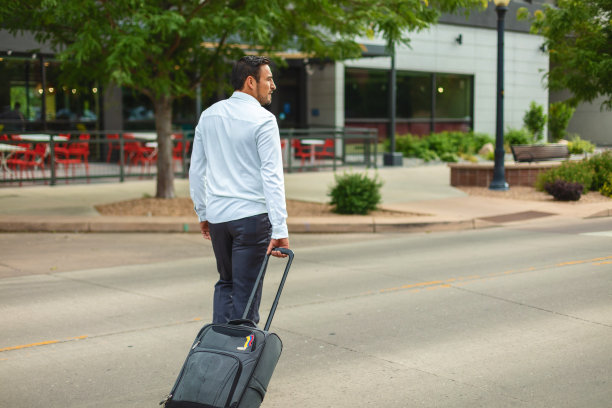 成年西班牙裔千禧一代男性接近酒店沿着城市街道旅游照片系列图片下载