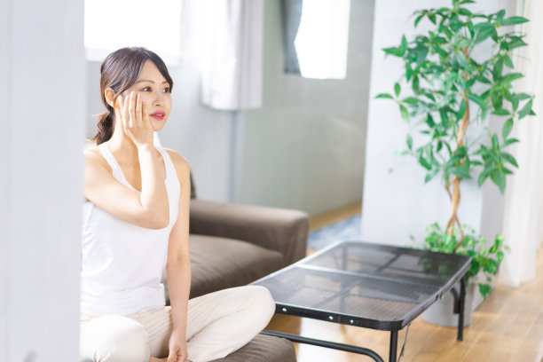 年轻的女人在她的房间里照顾她的皮肤图片下载