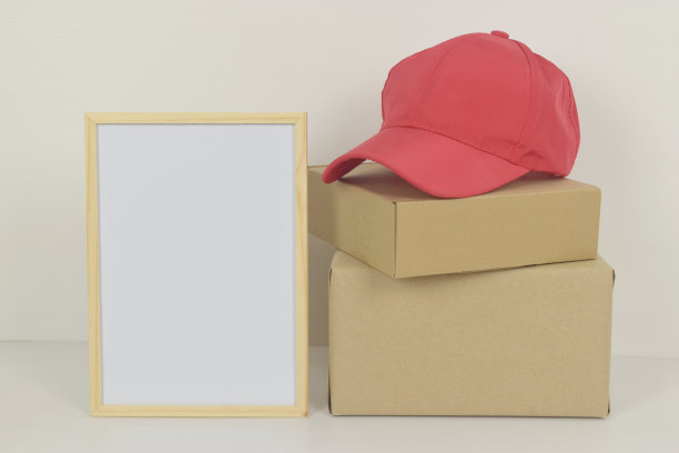 木制框架内的空白白板，边上有帽子和盒子。图片下载