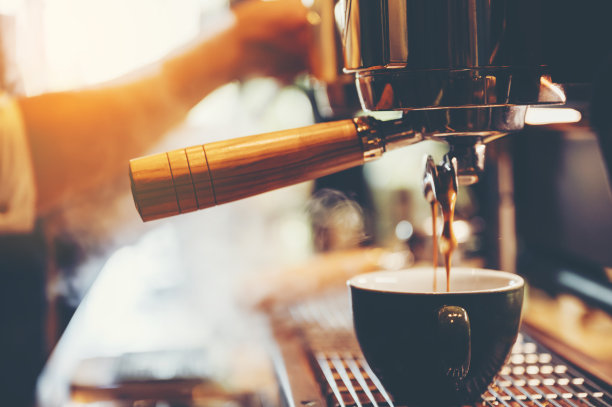 咖啡师在咖啡馆制作咖啡，从咖啡机热饮料杯，饮料餐厅业务，复古过滤器图像图片下载
