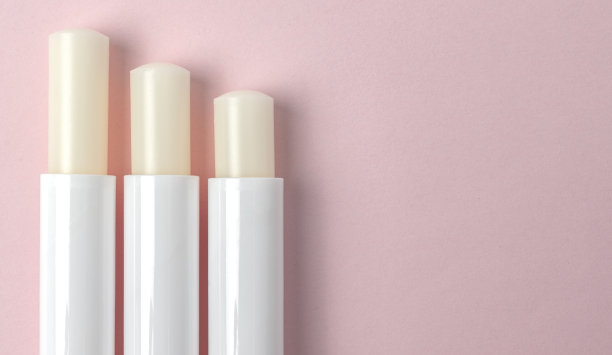 从上面看三个唇膏管在粉红色的背景。图片下载