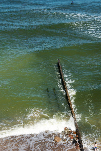 用圆木做的防波堤穿过海浪图片下载
