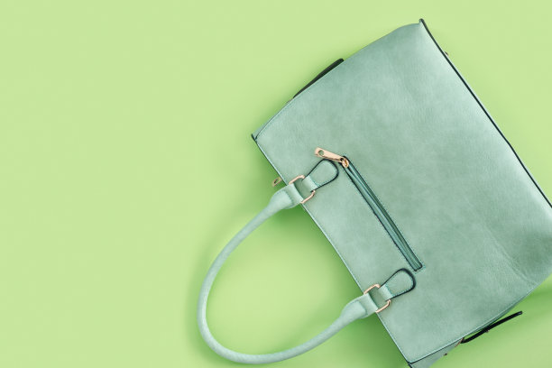 漂亮时尚的绿色袋子，精致的纸背景。图片下载