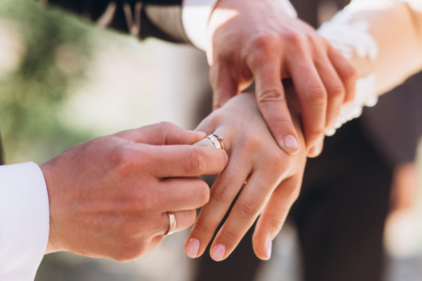 新娘和新郎手中的结婚戒指。图片下载