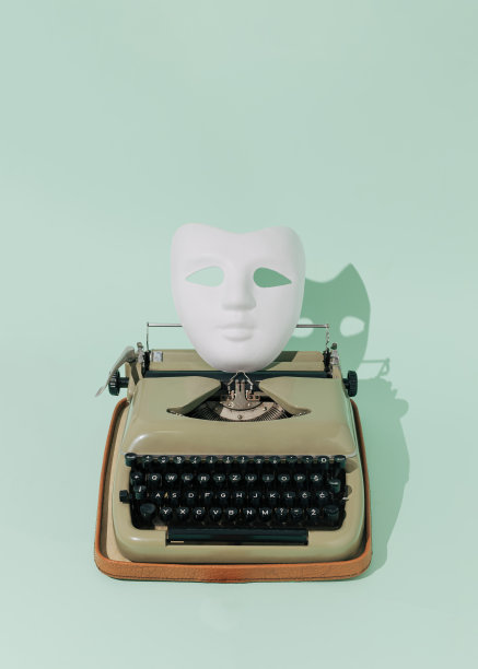 老式打字机和白色化妆舞会面具在亮绿色背景下。简约复古科技概念。晴天的影子。图片下载