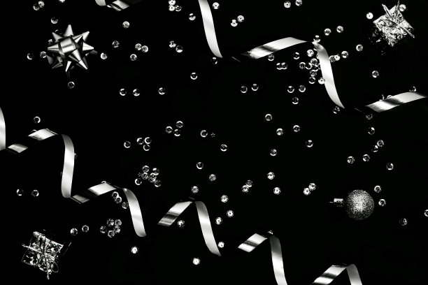 装饰礼物盒，球，银色流光，装饰蝴蝶结，星星和亮片在黑色背景。图片下载