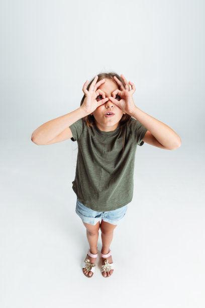 高角度的观点，美丽的幼儿园微笑的女孩孤立在白色的工作室背景。Copyspace广告。童年，教育，情感观念图片下载