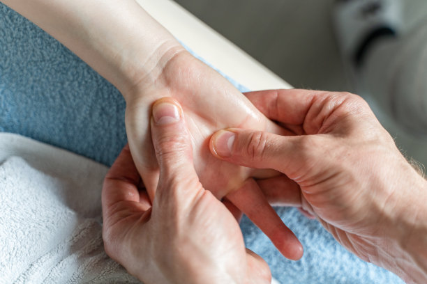 近距离观察无名白人男性治疗师的双手按摩和无名女性女性客户的双手伸展图片下载