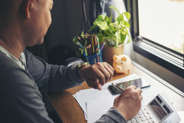 时间的概念。紧急工作，商人在开会前看手表和使用手机。高级职员在去办公室之前先检查一下时间表。约会会议暂停图片下载