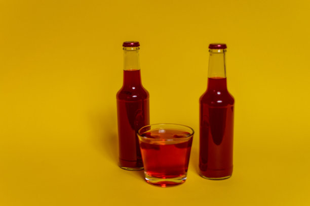 套瓶和玻璃杯，与彩色液体，冰块，饮料，酒精，鸡尾酒，马提尼在彩色背景。图片下载