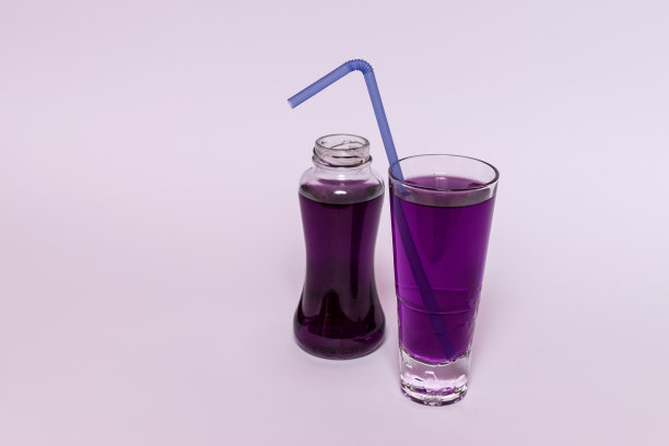 套瓶和玻璃杯，与彩色液体，冰块，饮料，酒精，鸡尾酒，马提尼在彩色背景。图片下载